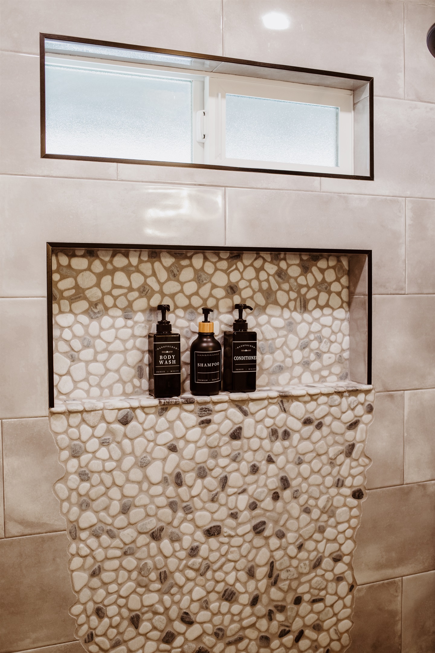 Indulge in a spa-like shower with premium products and designer stone accents.