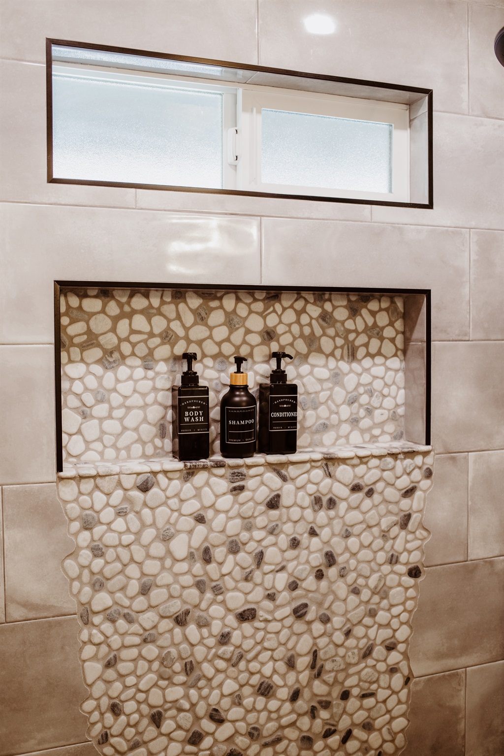 Indulge in a spa-like shower with premium products and designer stone accents.