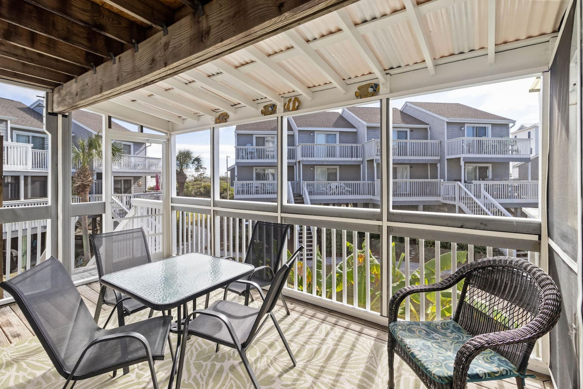 Sip something cold at the table or curl up in a chair &mdash; the screened deck is where mornings happen slowly and evenings go long.