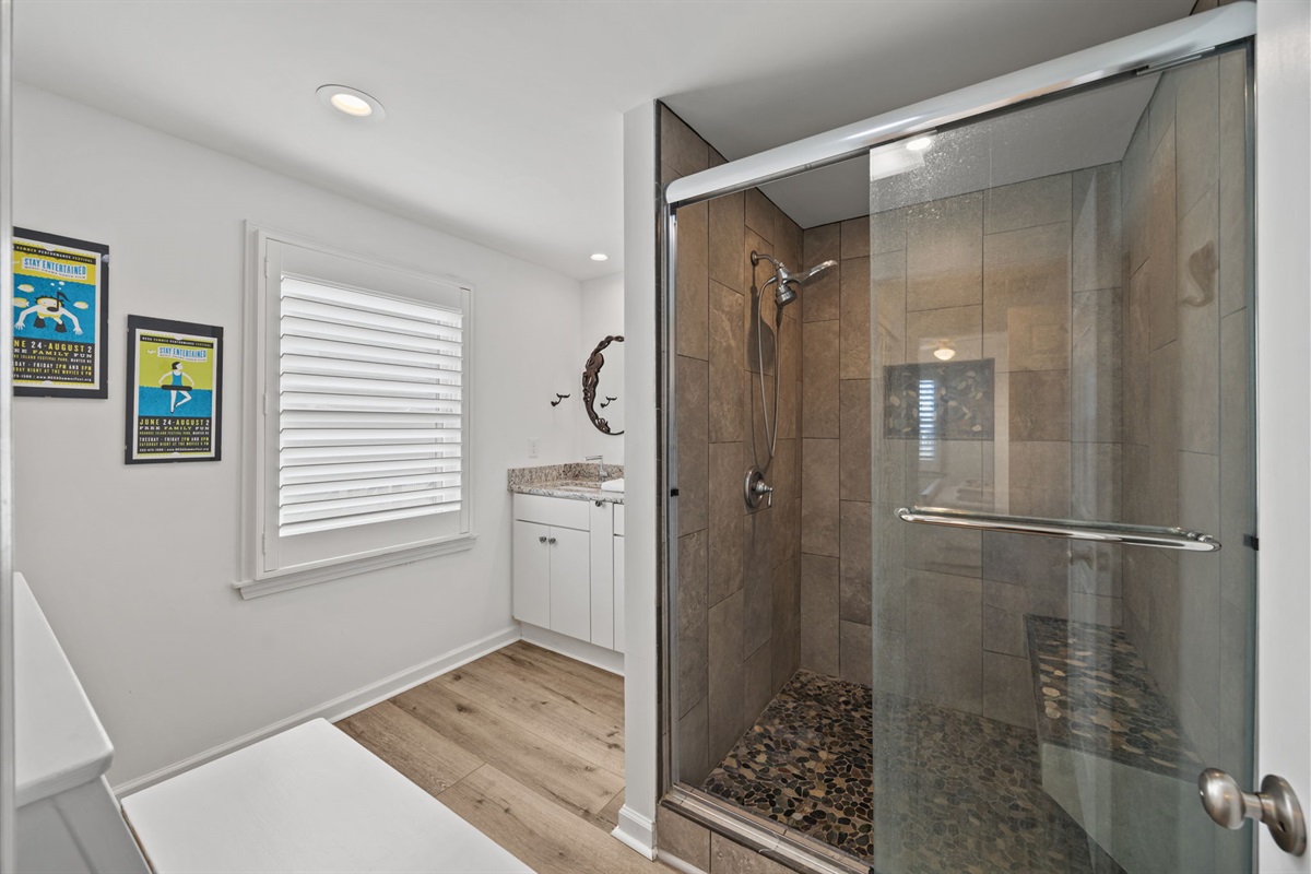 Walk-in glass shower with pebble floor