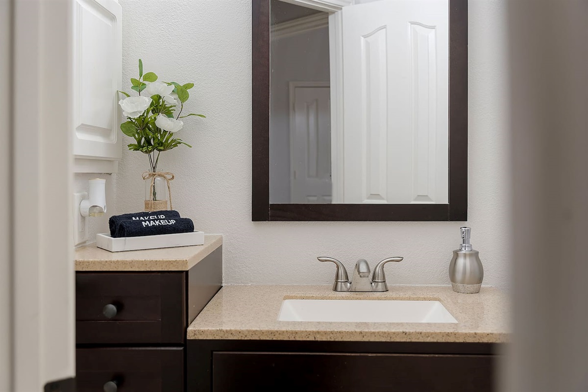Step into this luxurious bathroom featuring a sleek sink and mirror combo and a spacious walk-in shower. Pamper yourself in style and comfort.