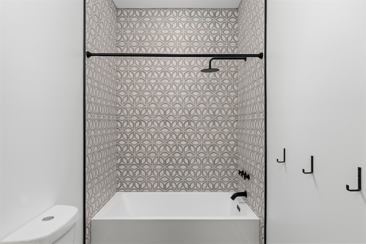 Stylish Bathroom: Unwind in a chic tub, surrounded by artful tile and modern fixtures!