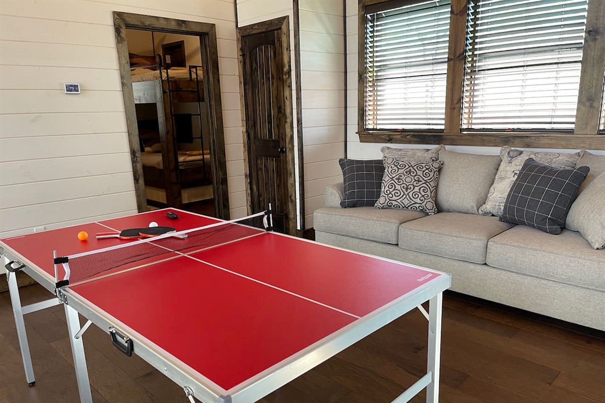 Ping pong table and new sleeper sofa, in the background is the bunk room.