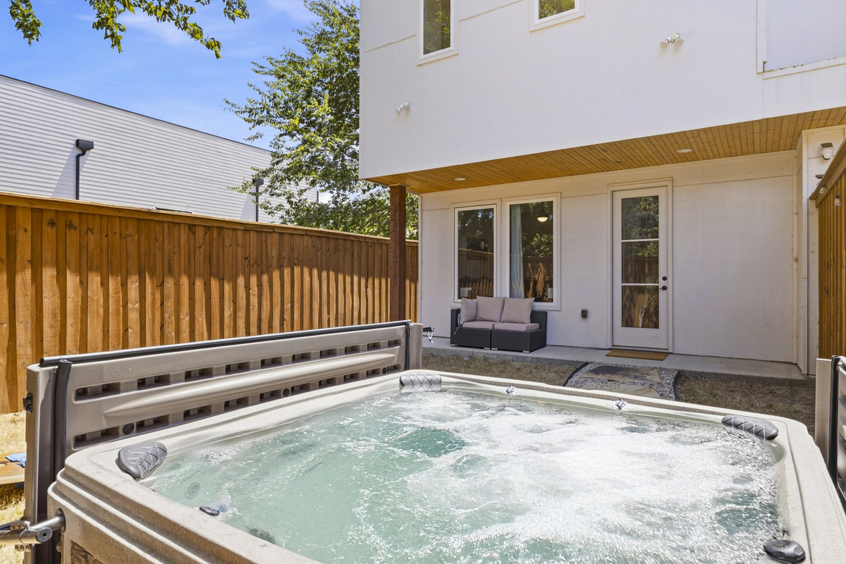 Unwind in the bubbling hot tub surrounded by serene outdoor seating!