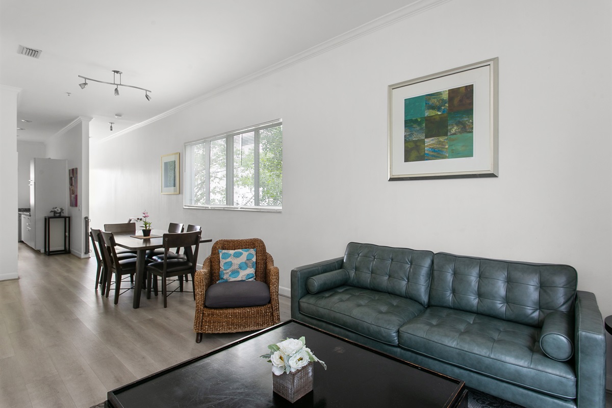 Open-concept living and dining, sliding glass doors open to a step-out balcony.