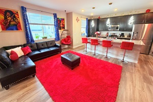 Open-concept lounge + kitchen with cozy sectional and island seating—perfect for group hangs.