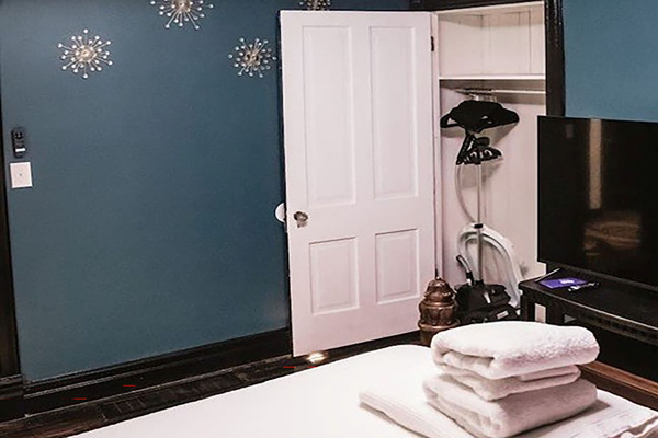 Closet holds a steamer, ironing board, and baby bathtub. Plenty of hangers for everyone.