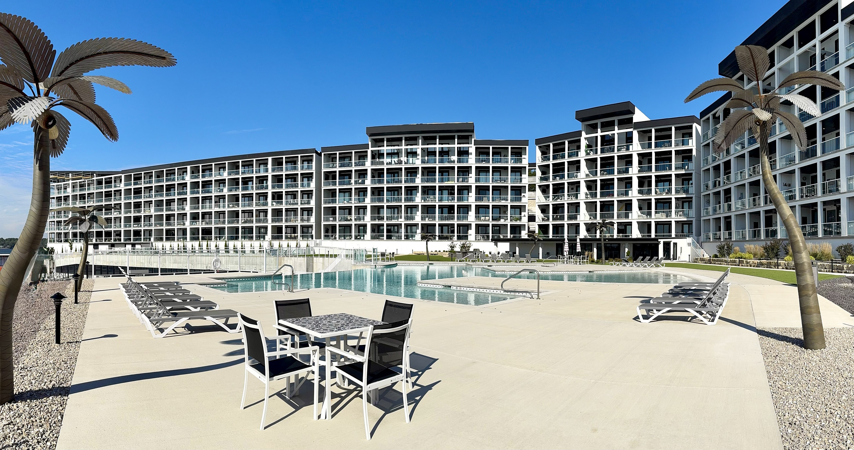 Pool 2 is located outside the community room in front of Building 4. Pool 2 has an infinity-edge waterfall with more loungers and tables/chairs. A set of bathrooms is located near each pool.