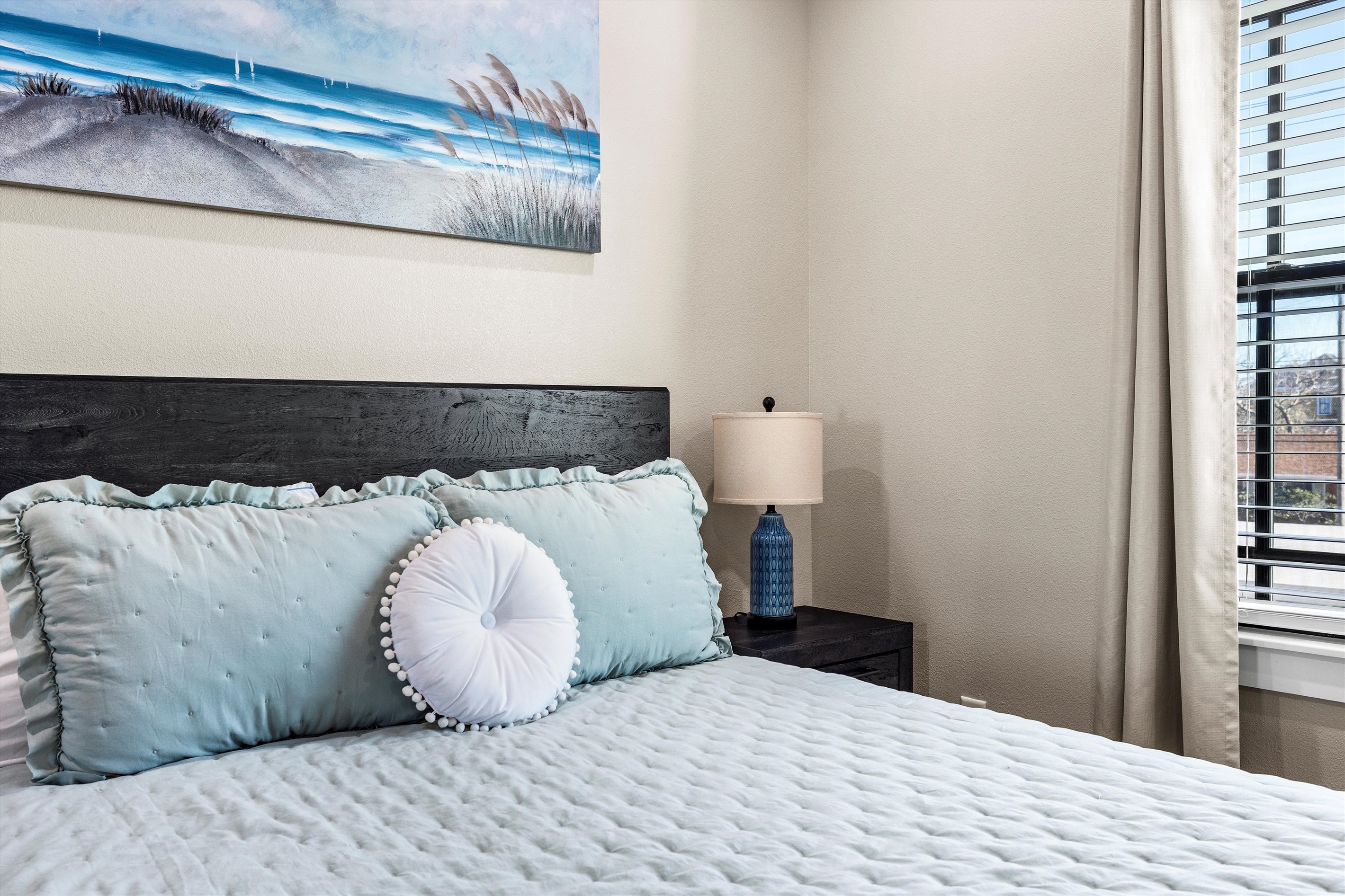 Charming Bedroom: Wake up inspired by beachy decor and gentle natural light streaming in!