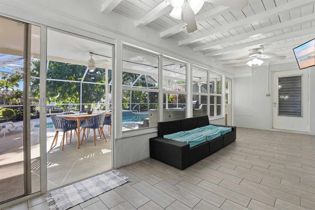 Game room with bar table, couch, TV and foosball table. 