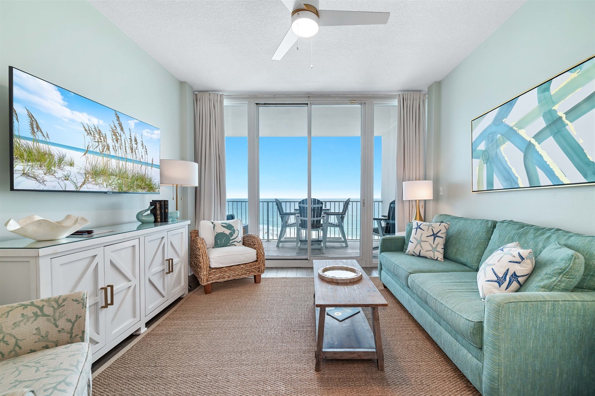 Bright and airy living area with a stunning view of the water. The space is complete with a comfortable sleeper sofa, perfect for relaxing after a day at the beach.