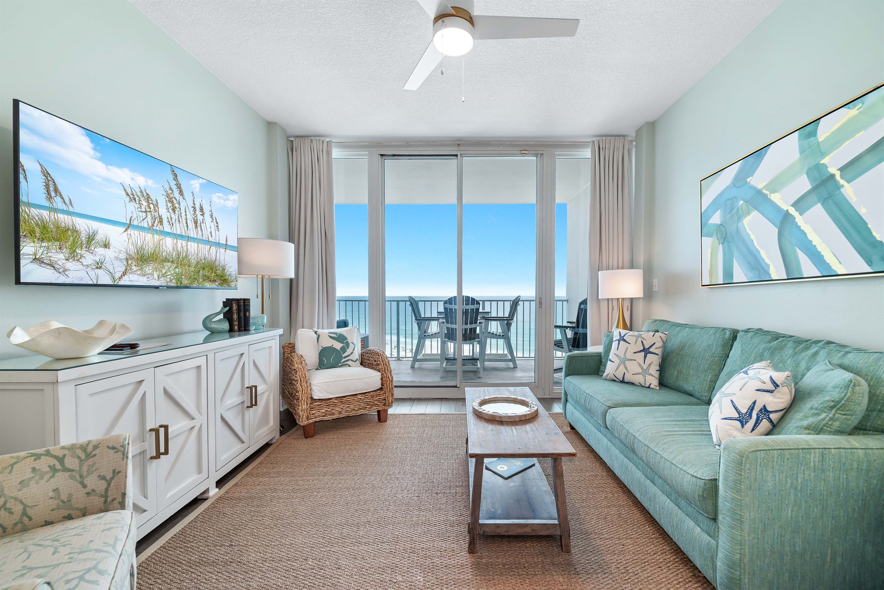 Bright and airy living area with a stunning view of the water. The space is complete with a comfortable sleeper sofa, perfect for relaxing after a day at the beach.