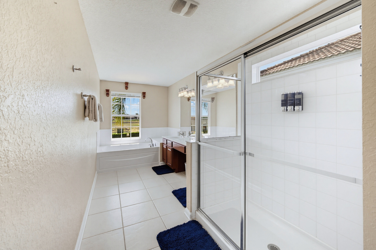 Primary en-suite w/ walk-in shower, garden tub, & dual vanity 