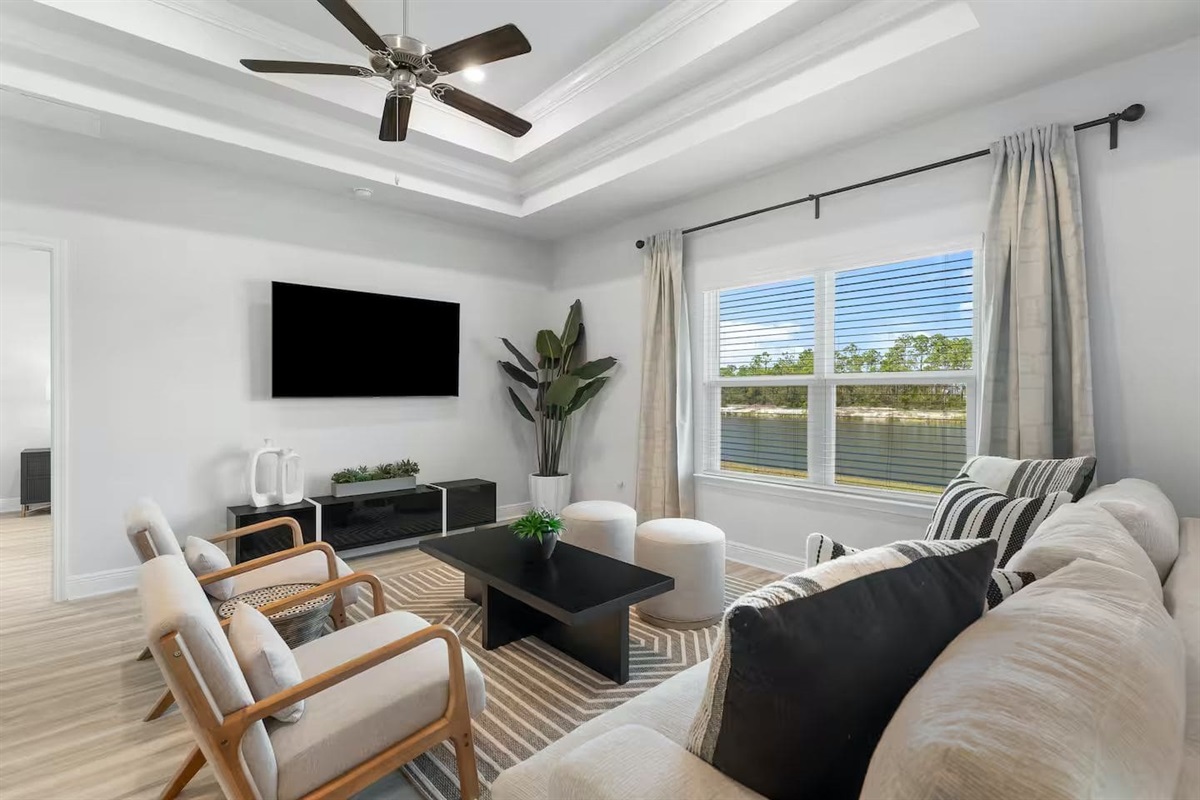 A beautifully styled comfortable living room with Smart TV, Ceiling fan and Natural light