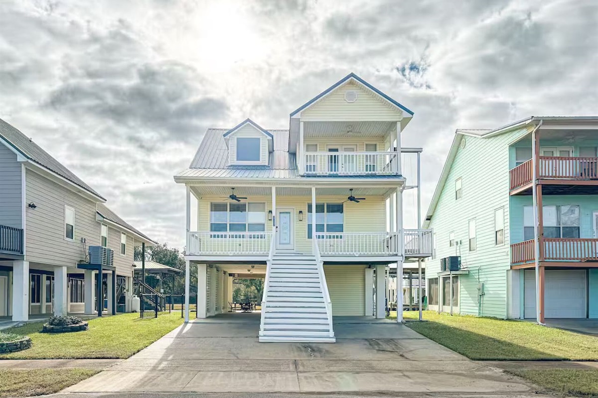 Beautiful elevated coastal home with spacious balconies, private parking, and a bright, welcoming exterior