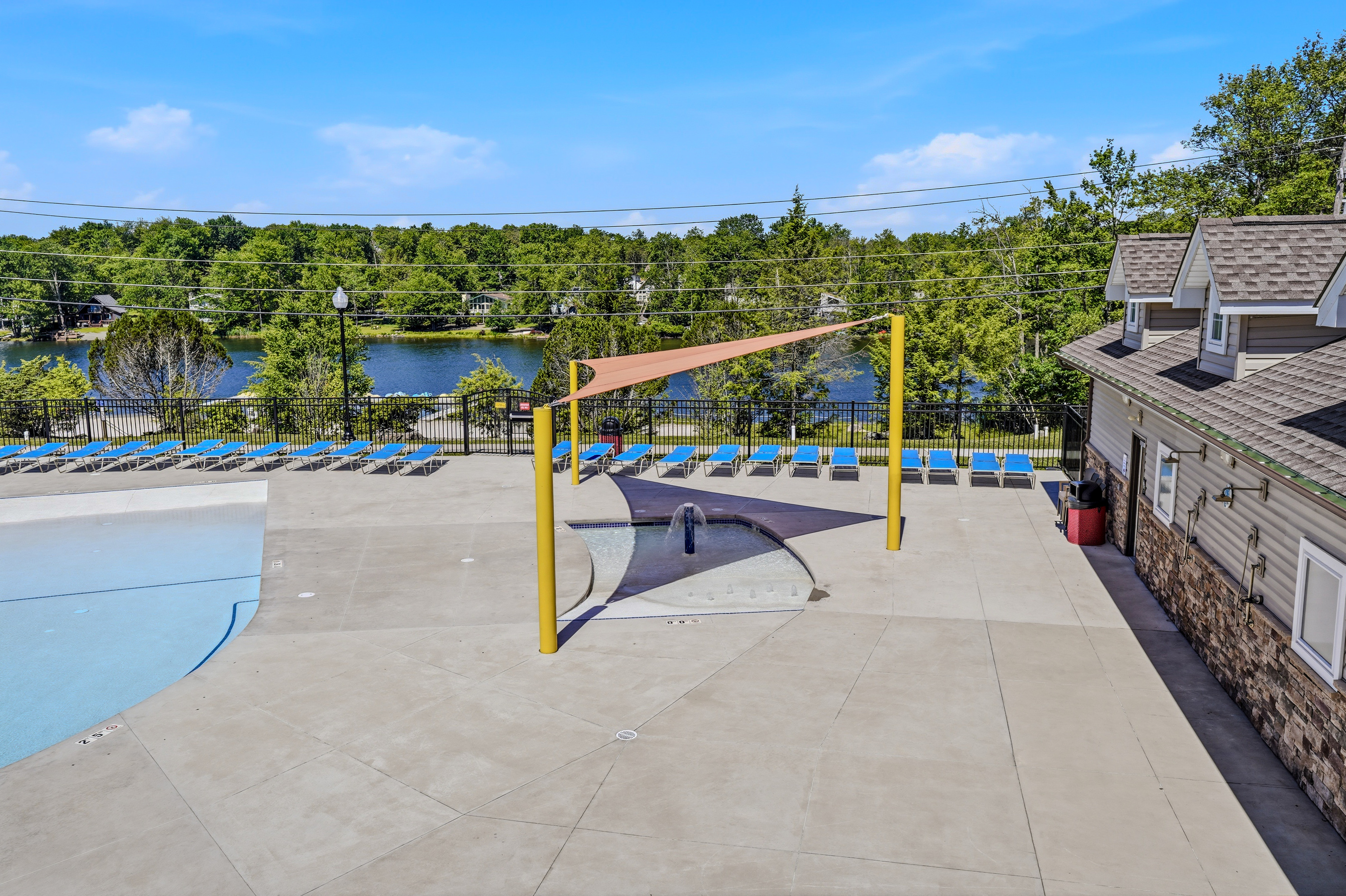 Community pool with volleyball net and expansive deck — summer fun included