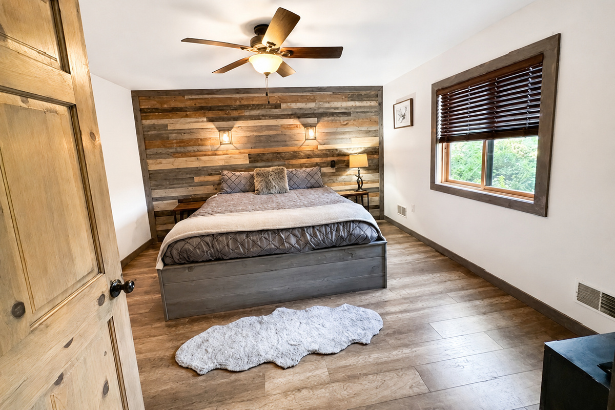 Comfortable private bedroom with warm wood accents, ceiling fan, natural light, and a relaxing Northwoods atmosphere for unwinding after a full day of Wisconsin adventures.