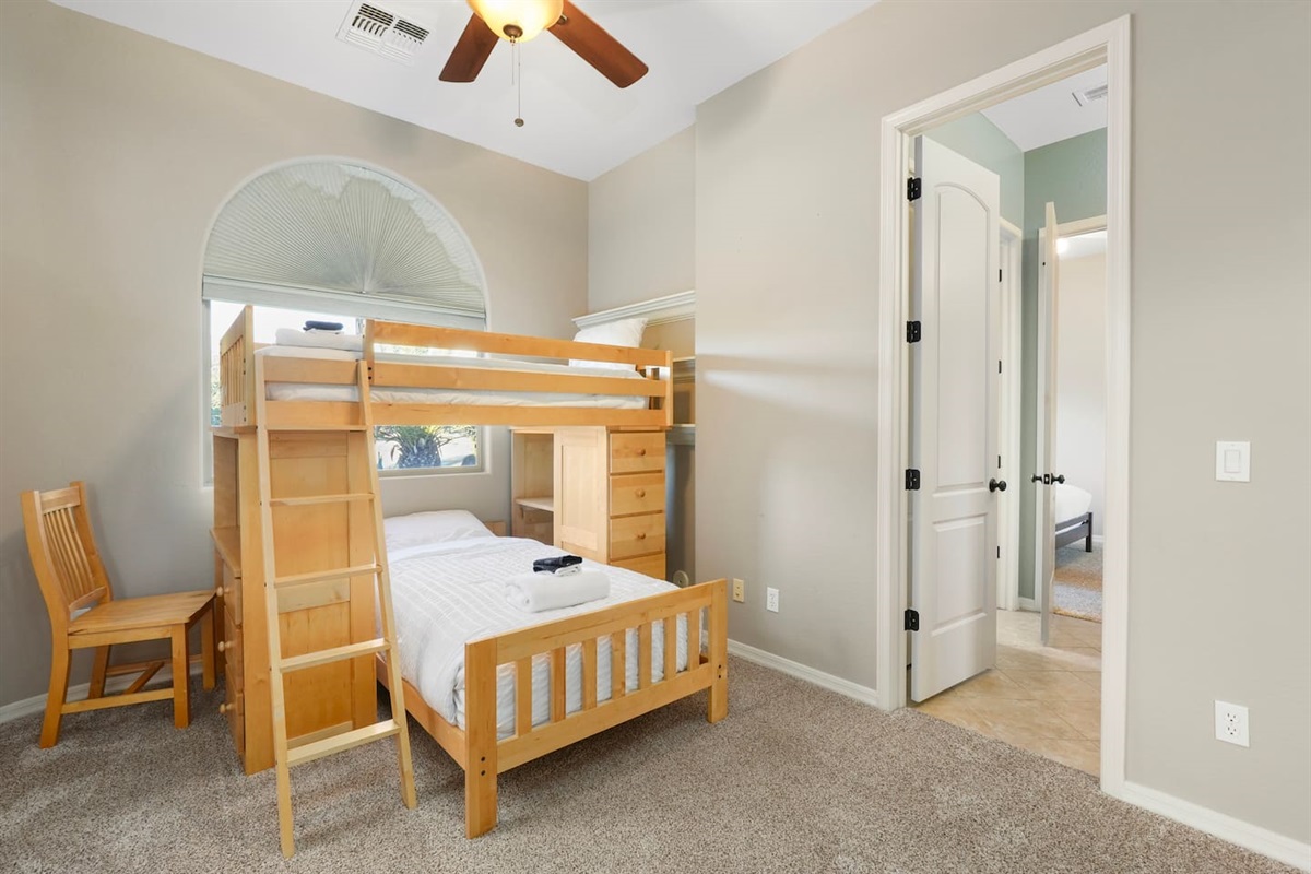 Family-friendly bedroom with twin-over-twin bunk bed, built-in storage, and a small workspace.