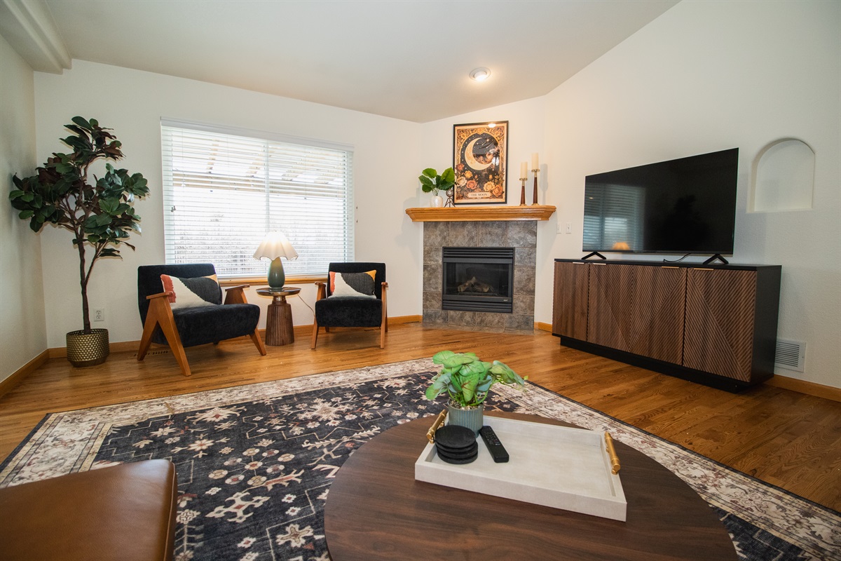 Enjoy a spacious and warm living area with high-ceilings, moody finishes, smart tv, and comfortable seating