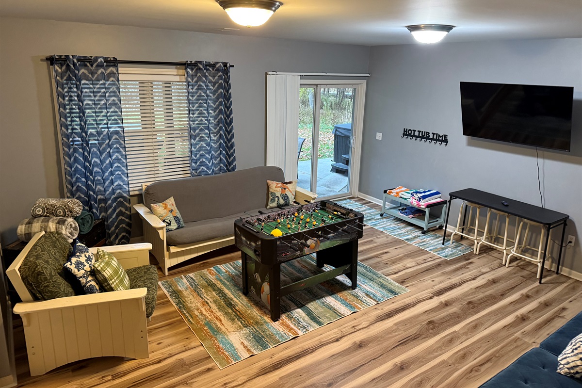 Walkout level living room equipped with smart television, games and foosball table. Walkout the sliders to patio,hot tub, and THE LAKE!