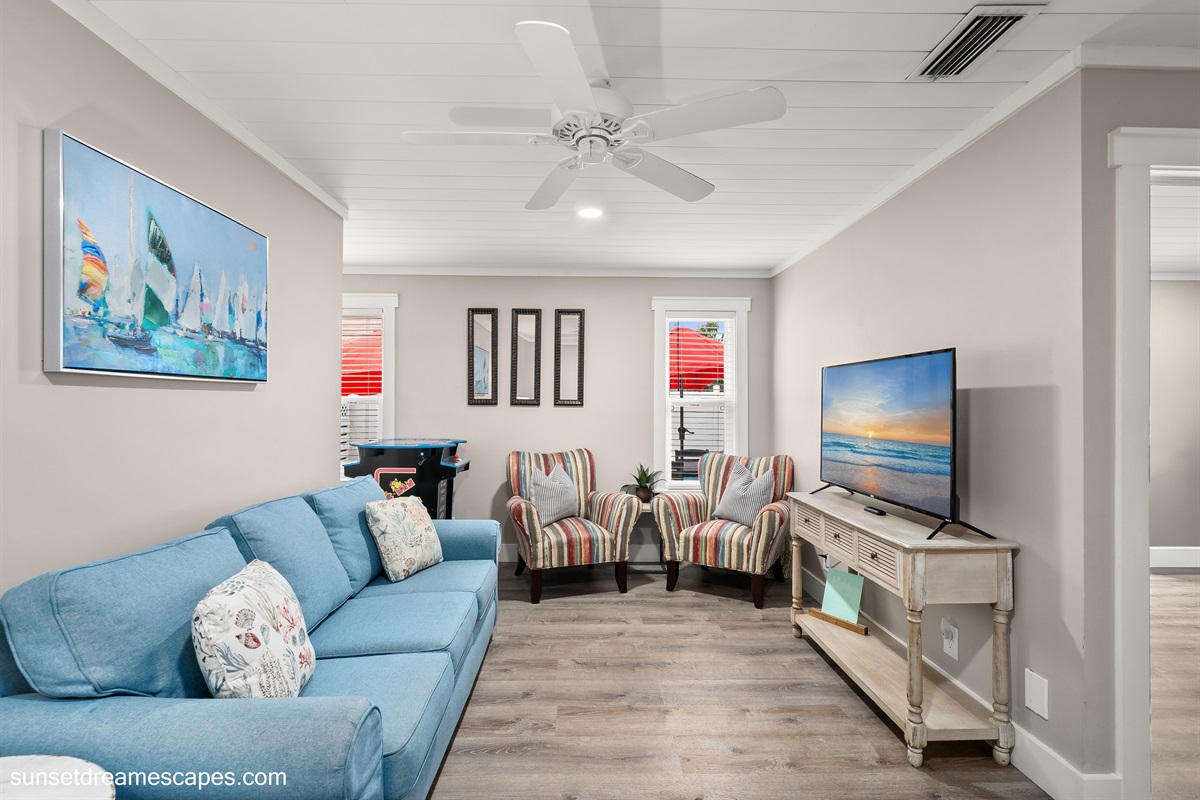 Stepping through the downstairs bunkbed room leads to the secondary living room located in the rear of the home. There is a large smart TV and comfortable seating.