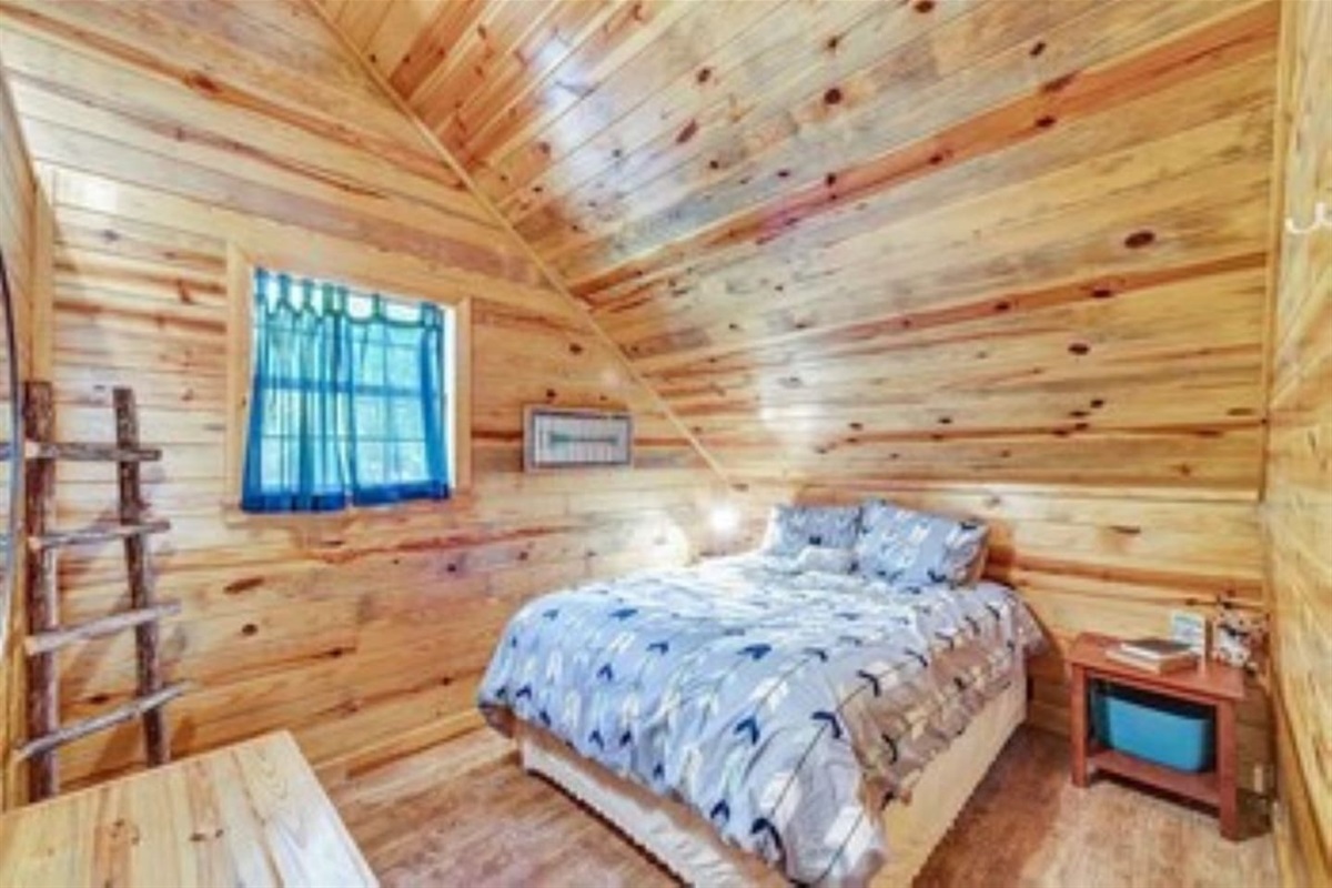 Queen size bed in loft area.