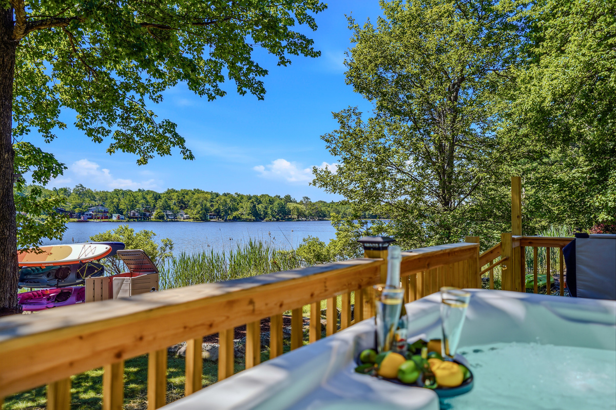 Hot tub deck with champagne and lake view — the good life, right here