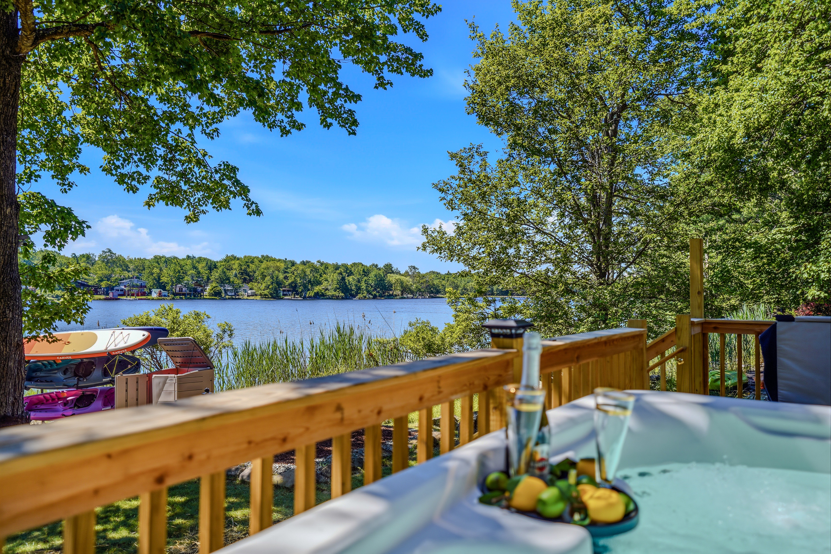 Hot tub deck with champagne and lake view — the good life, right here