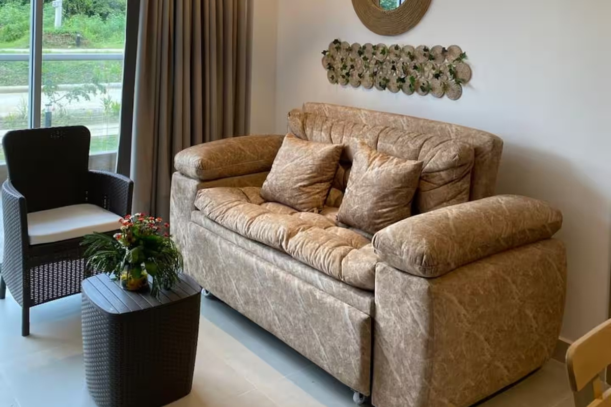Zona de estar relajada con sofá acolchado, sillón y mesa de centro, ofreciendo un espacio cómodo para descansar en el interior.
