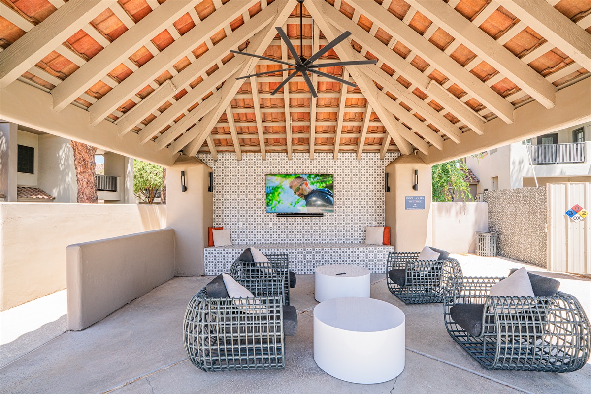 Vibrant courtyard with games, string lights, and lush green space for fun and relaxation.