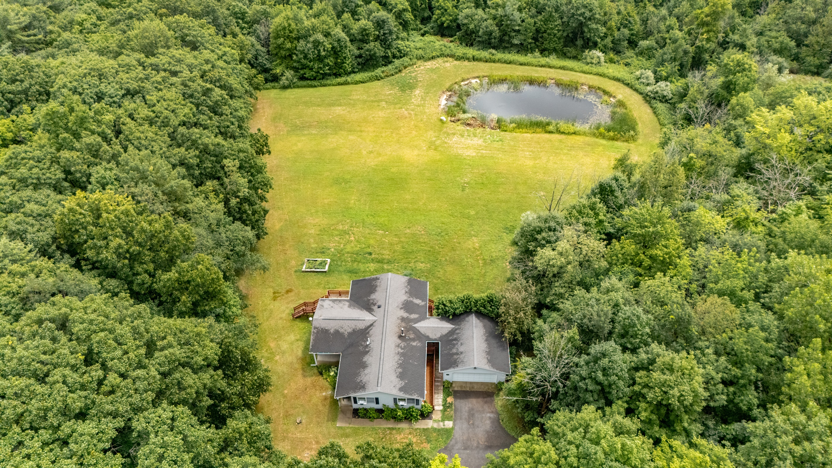 Nestled in total privacy, this charming home overlooks a lush clearing and serene private pond—your own secluded sanctuary.