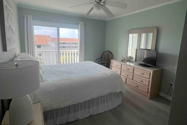 Relax in this airy Myrtle Beach master bedroom featuring soft coastal tones and a private balcony view.