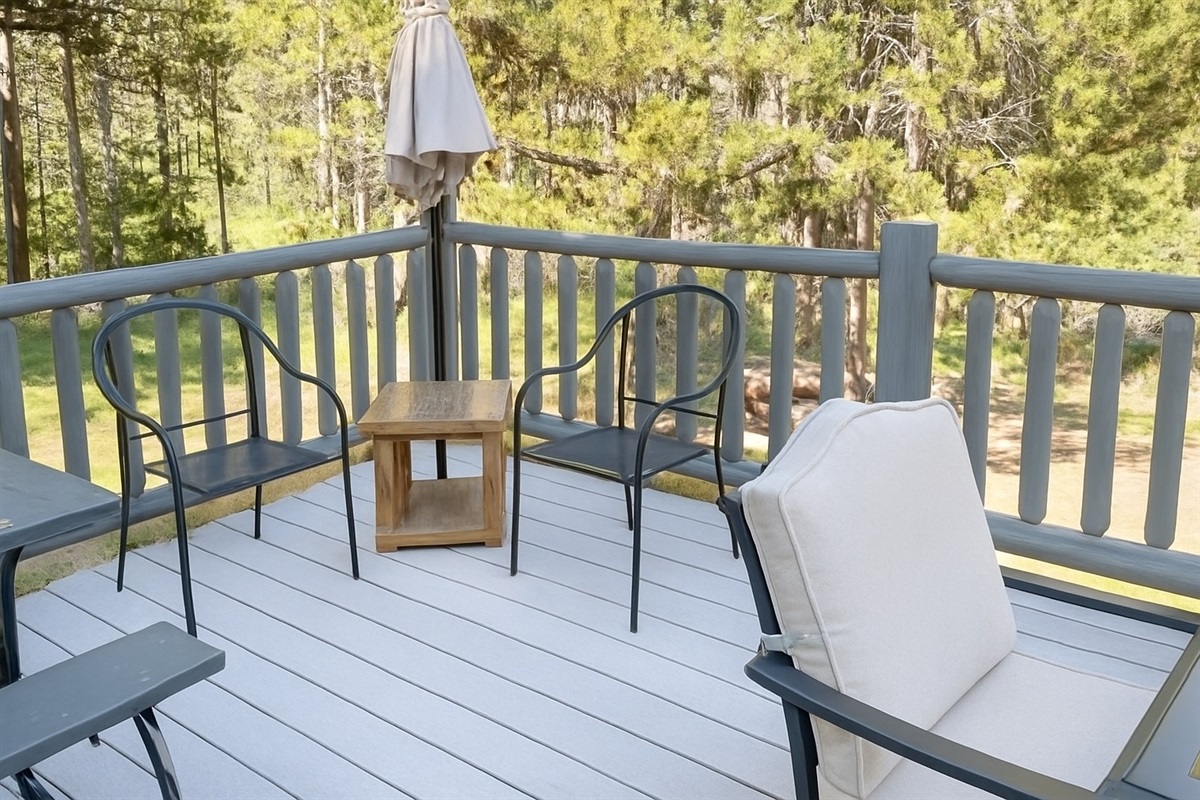 Cozy deck seating with peaceful tree-lined views