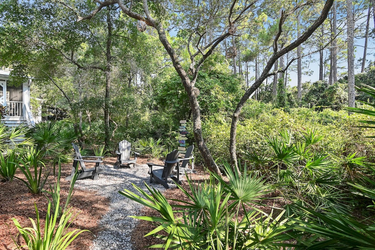 Peaceful backyard with seating for four, you’ll find a lush, wooded lot filled with a mix of coastal pines, native palms, and natural greenery. This serene landscape creates a peaceful, private retreat.