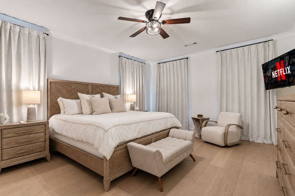 Rest easy in the luxurious main-level king master suite at Pool Villa Lanier, featuring soft neutral tones, luxury linens, room-darkening curtains, a full-length mirror, private TV, extra-large walk-in closet, and spa-like master bathroom all on main floor