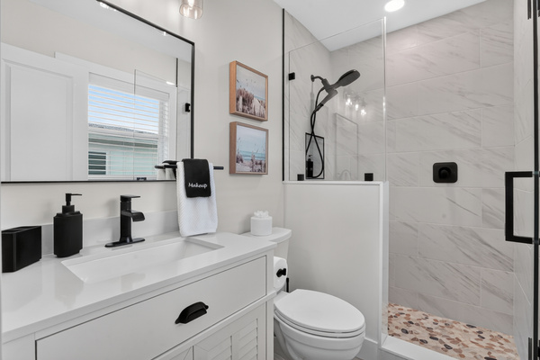 The primary bathroom features a spacious walk-in shower and clean, modern finishes.
