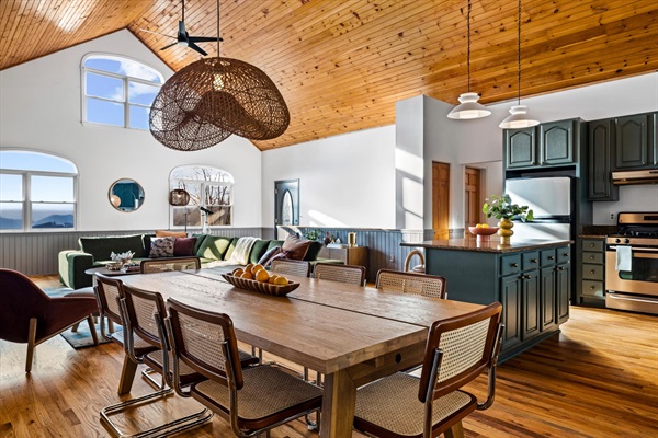 Open-concept kitchen, dining, and great room with mountain views—ideal for group gatherings, shared meals, and spending time together in one connected space.