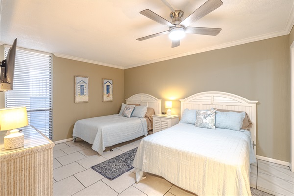 Third bedroom with two beds, ceiling fan, smart TV, and access to the 3rd bathroom