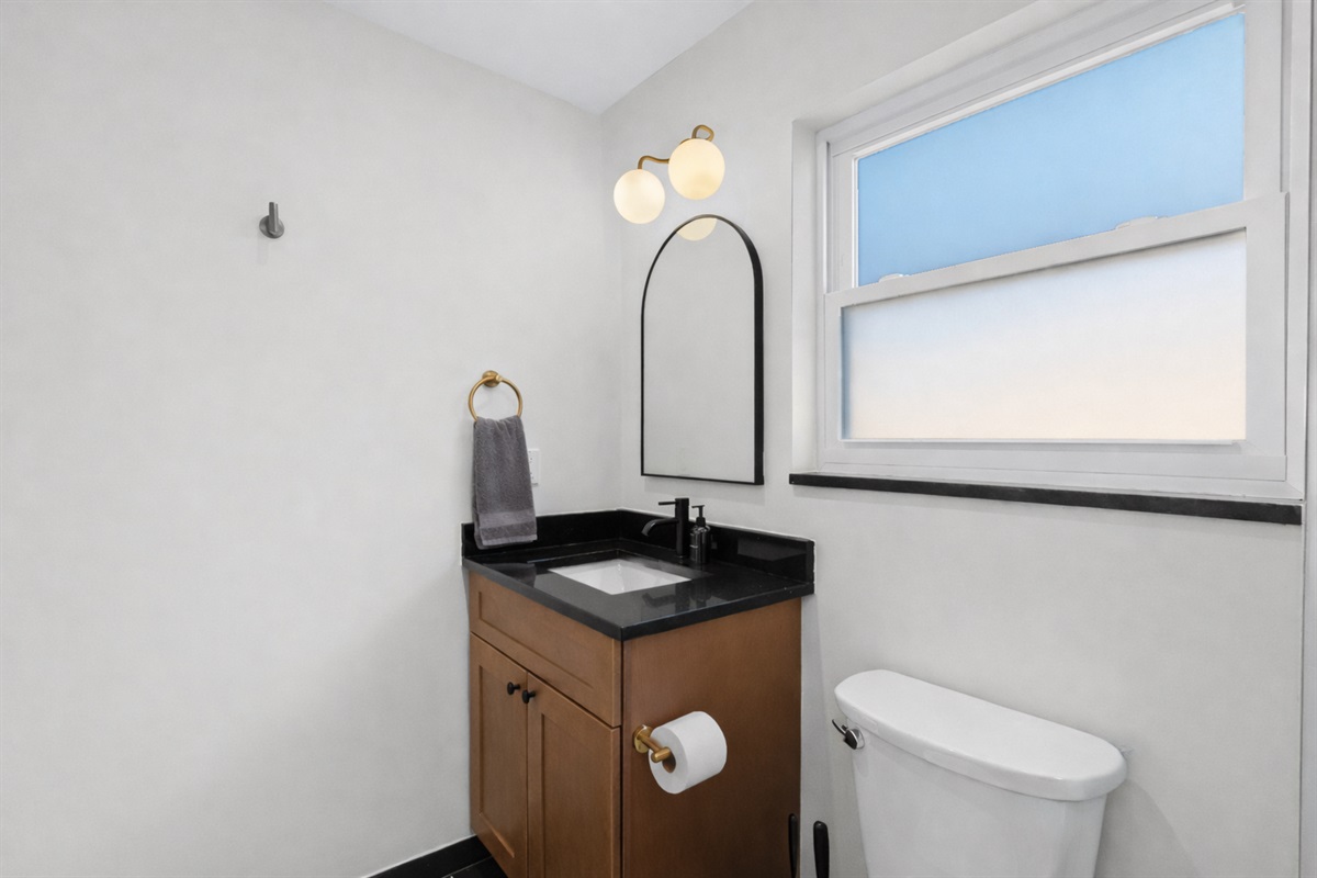 Clean, modern bathroom with stylish vanity, warm lighting, and a bright window—offering a fresh, comfortable space to start or end your day.