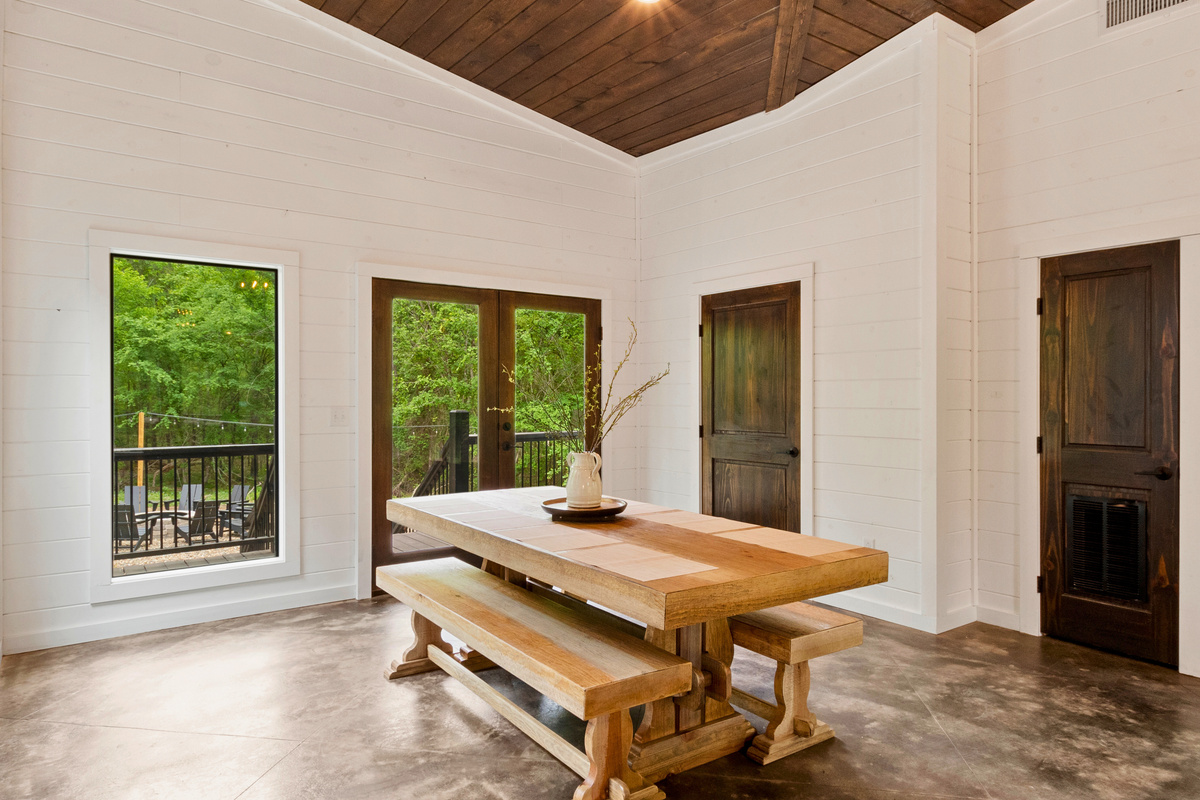 This dining area is all about rustic charm, with a sturdy wooden table and views of the woods, creating the perfect setting for a feast or a family game night.