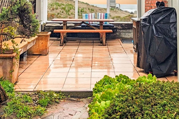 - Outdoor patio with picnic table, string lights, and views of the dunes  
- Features BBQ grill for easy outdoor cooking and dining experiences  
- Enclosed design offers a cozy gathering space in all seasons