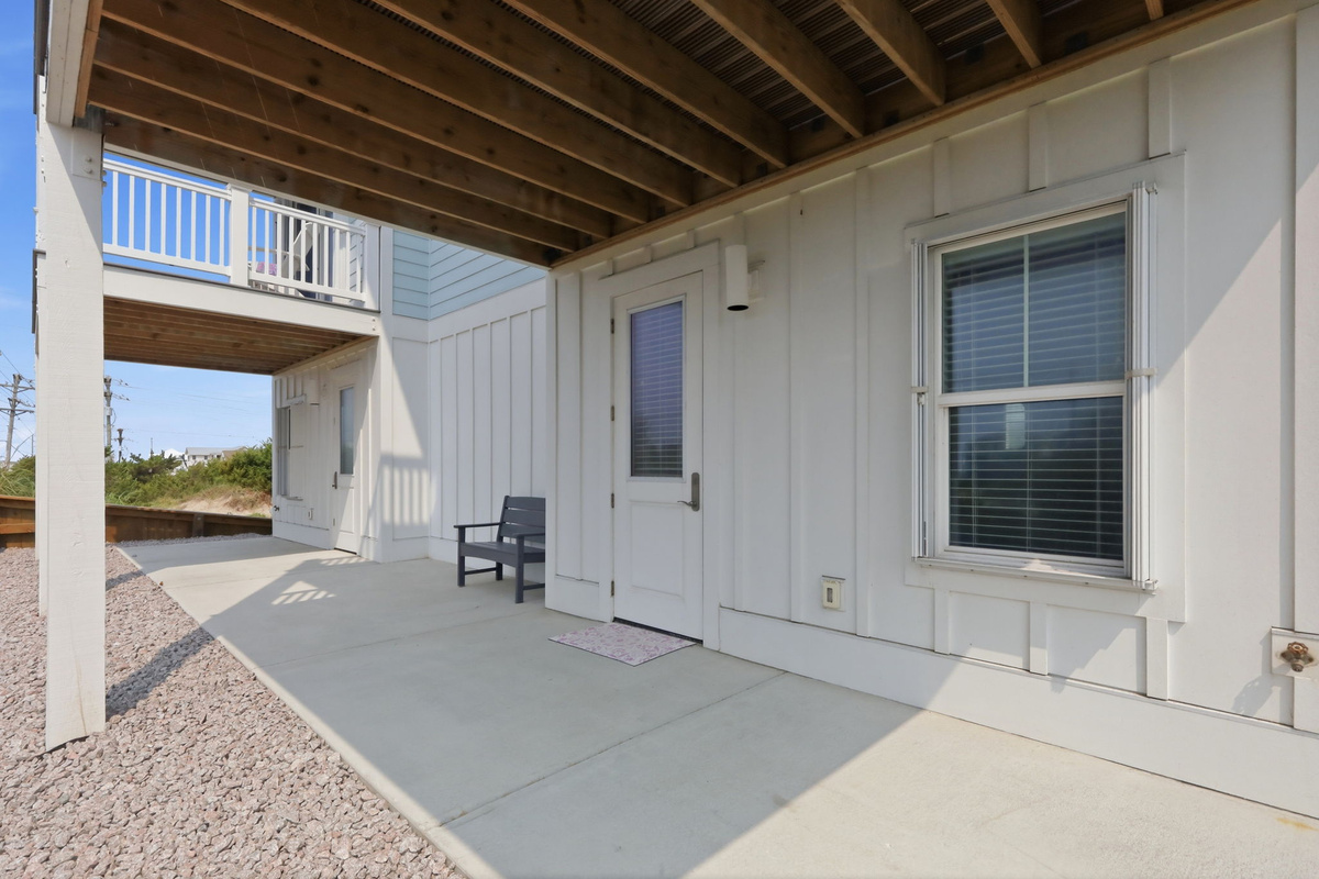 Ground-level patio entrance providing easy access to the home with a covered outdoor area for relaxing and enjoying the fresh coastal air