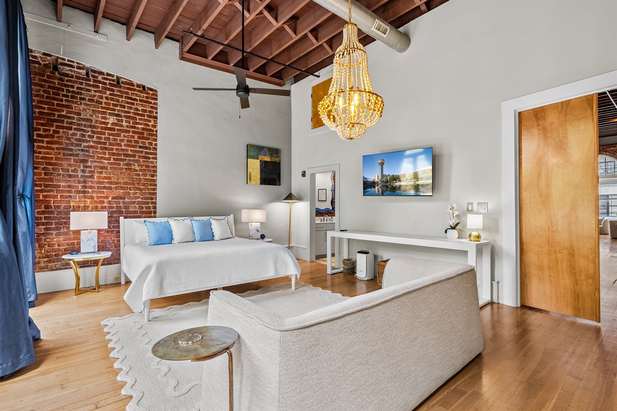 Master bedroom with king bed, private balcony, lounge seating, and ensuite bathroom.
