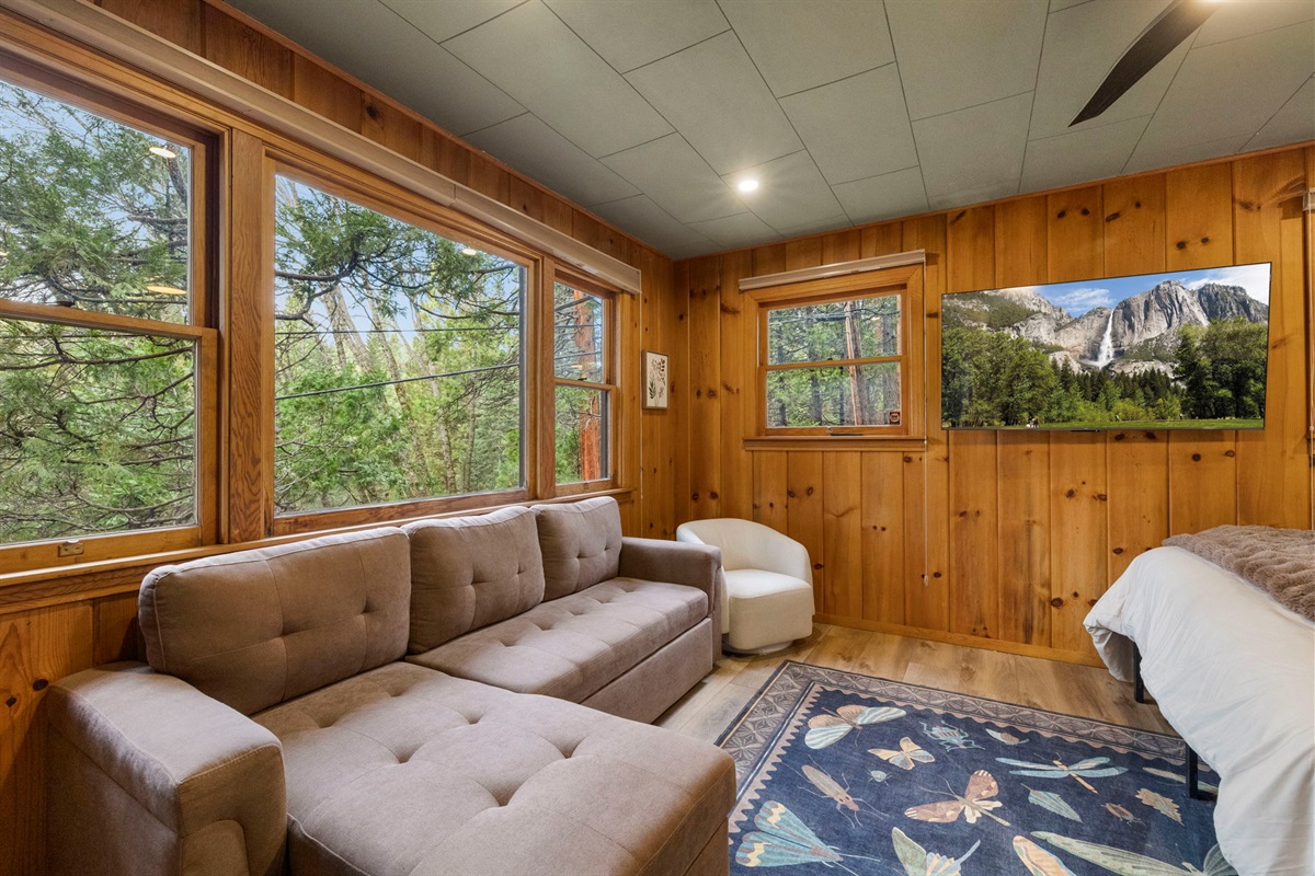 Sofa and child's chair to watch TV. Sofa also has extra pillows and blankets in the chaise lounge spots and can pull out to be a full bed for sleeping on.