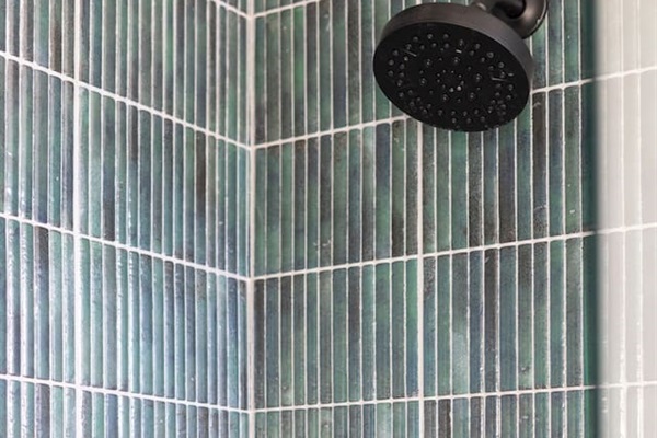 Close-up of the rainfall showerhead and elegant tile detail for a spa-like experience.