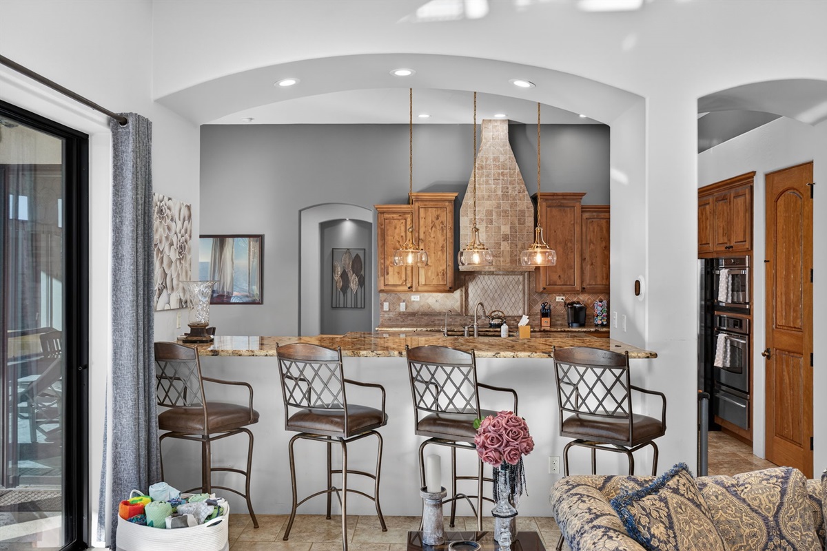 Breakfast bar seating beside the kitchen island creates a social hub for morning coffee and casual conversation