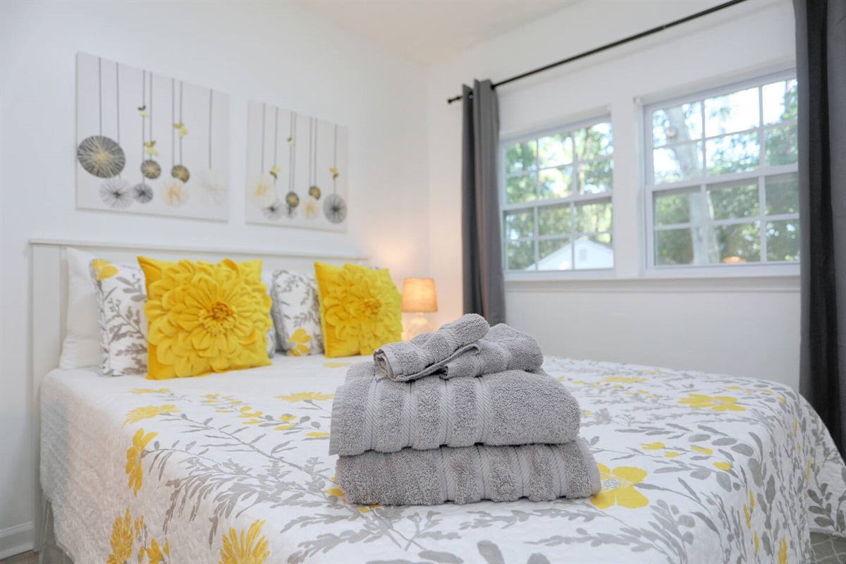 Unwind in the third bedroom, featuring a comfortable queen bed, a convenient desk for work or planning your day, and extra pillows for added comfort.