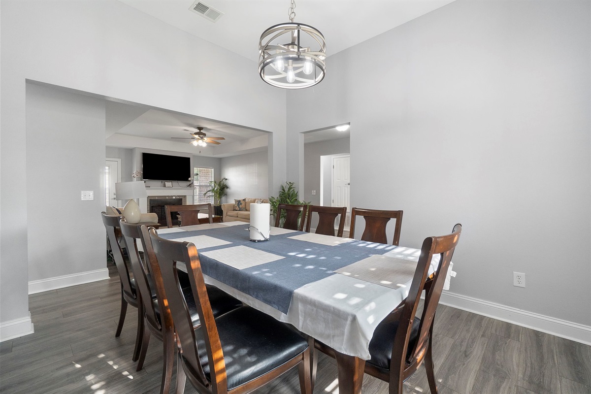 Whether you're hosting a family dinner or enjoying a quiet breakfast, this inviting dining room has you covered. The modern chandelier, sleek flooring, and comfortable seating create a sophisticated yet homey vibe.