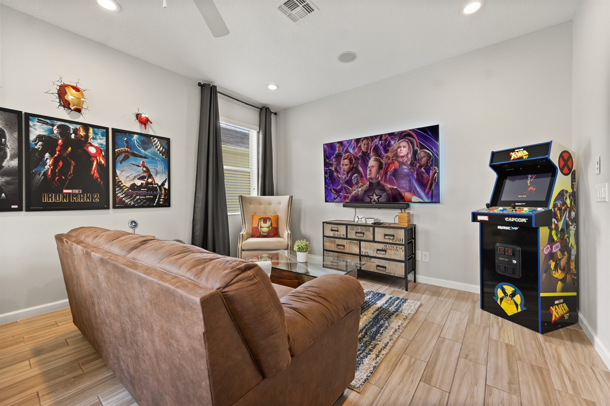 The Marvel inspired game room has a comfortable sofa to watch your favorites movies at the 55' TV.