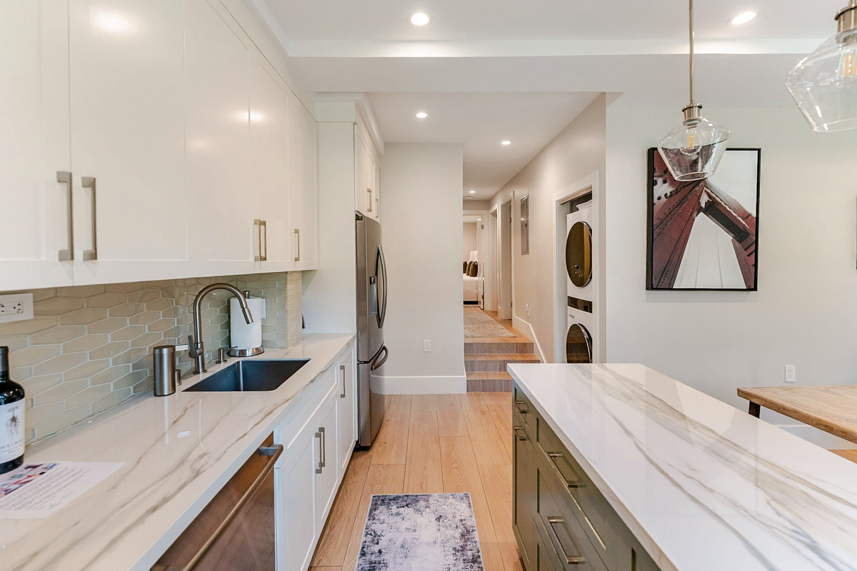 Fully-equipped chef's kitchen with counter and island stocked with cooking appliances and equipment and most everything needed for dining and drinking comfort.  